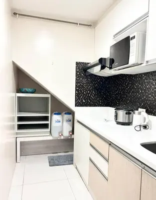 a kitchen with a white counter and a microwave at 2 Bedroom Loft at Twin Oaks Place in Manila