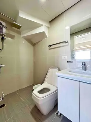 a bathroom with a white toilet and a sink at 2 Bedroom Loft at Twin Oaks Place in Manila