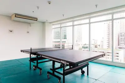 a ping pong table in a room with a large window at Book Now for Free Pool And Sauna Access Inside Prime Location Of Manila near US Embassy, NAIA, Makati, BGC, Mall of Asia, Chinatown. Immerse in Sea View Balcony for Limited Time Offer This Month Click Here Now in Manila