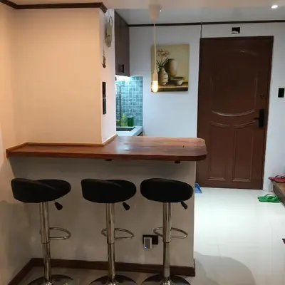 a kitchen with a counter with stools under it at Stay in Manila, Cambridge Village in Cainta