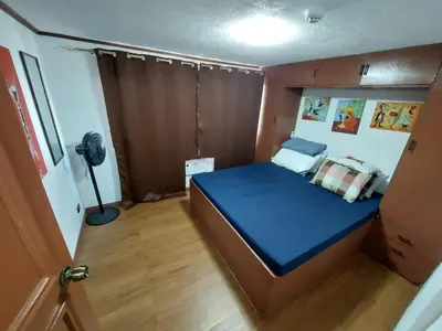 a small bedroom with a blue bed in it at Stay in Manila, Cambridge Village in Cainta
