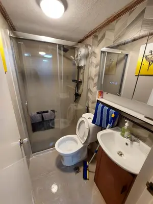 a bathroom with a shower and a toilet and a sink at Stay in Manila, Cambridge Village in Cainta