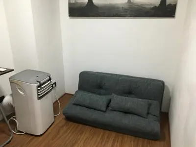 a green couch in a corner of a room at Stay in Manila, Cambridge Village in Cainta