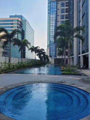 a large swimming pool with palm trees in a city at Eastwood Staycation Home with Stunning City View minimum 2nights stay in Manila