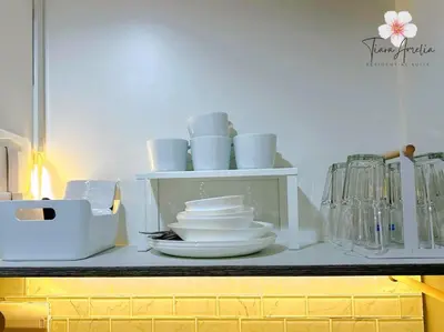 a shelf with plates and dishes on a kitchen counter at Condo near MOA Pasay and NAIA Manila Airport in Manila