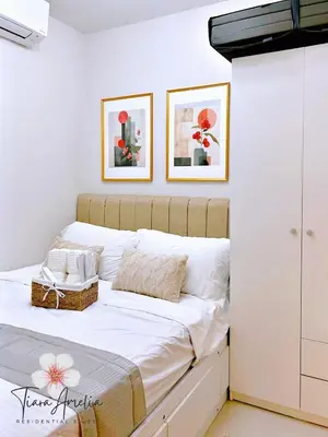 a bedroom with a white bed with two pictures on the wall at Condo near MOA Pasay and NAIA Manila Airport in Manila