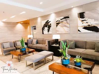 a living room with couches and tables and paintings at Condo near MOA Pasay and NAIA Manila Airport in Manila