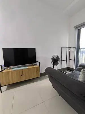 a living room with a large flat screen tv at Fame Residence 701 Tower 2 in Manila