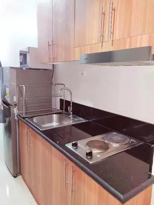 a kitchen with a sink and a stove top oven at Condo near Mall of Asia in Manila