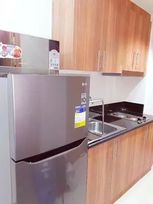 a kitchen with a stainless steel refrigerator and a sink at Condo near Mall of Asia in Manila