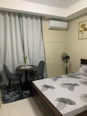 a bedroom with a bed and a table with chairs at Milia Condo w/ Free use of Swimming pool & Gym in Manila