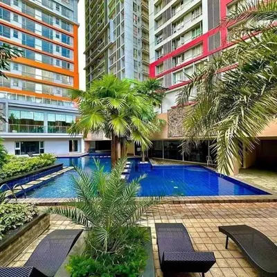 a swimming pool with palm trees and buildings at Milia Condo w/ Free use of Swimming pool & Gym in Manila