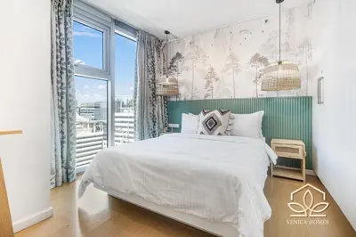 a bedroom with a bed and a large window at Tropical Oasis w/ the best view of BGC + Netflix in Manila