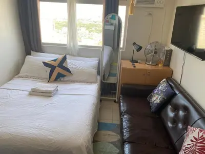 a small bedroom with a bed and a couch at Pierrecondotel in Manila