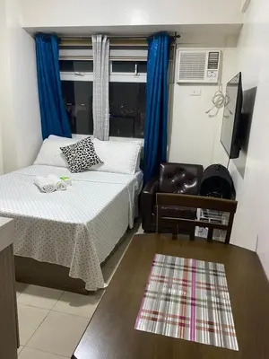 a bedroom with a bed and a chair and a window at Pierrecondotel in Manila