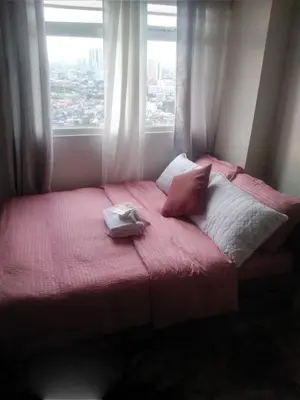 a bed in a room with a large window at Pierrecondotel in Manila