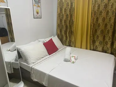 a small room with a bed with white sheets at pierrecondotel in Manila