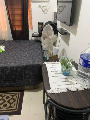 a bedroom with a table and a bed and a table and chair at pierrecondotel in Manila