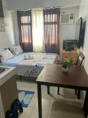 a small room with a bed and a table in it at pierrecondotel in Manila