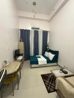 a living room with a bed and a table at Simple Yet Special n SOUTH RESIDENCES in Manila