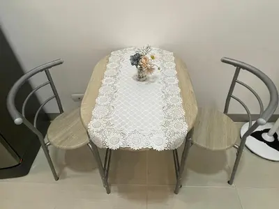 a table with a vase of flowers and two chairs at Simple Yet Special n SOUTH RESIDENCES in Manila