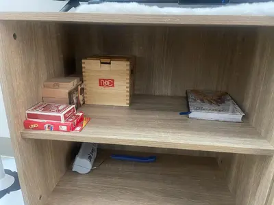a wooden shelf with boxes and books on it at Simple Yet Special n SOUTH RESIDENCES in Manila