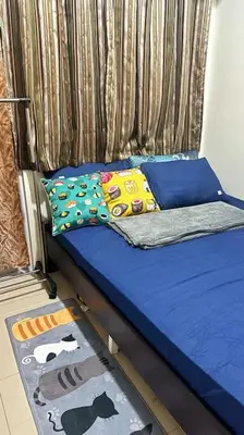 a bed with blue sheets and pillows on it at Meowcation Condo in Makati in Manila