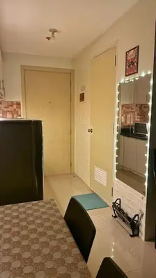 a room with a bed and a door to a kitchen at Meowcation Condo in Makati in Manila