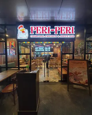 a restaurant with a sign and tables and chairs at Stylish 2br with View at BGC Uptown Parksuites 29a in Manila