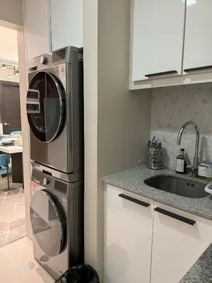 a kitchen with a washing machine and a sink at Stylish 2br with View at BGC Uptown Parksuites 29a in Manila