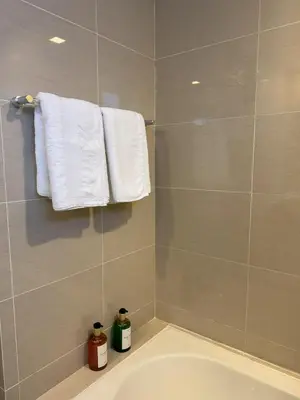 a bathroom with a tub and towels on a wall at Stylish 2br with View at BGC Uptown Parksuites 29a in Manila
