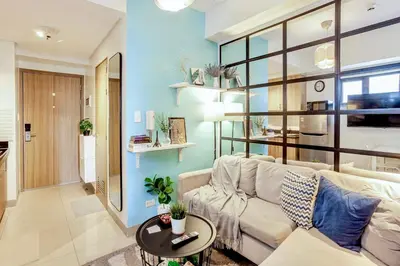 a living room with a couch and a table at ClaySky Staycation S2T1-Cozy & Homey 1BR Apartment near MOA facing Pool with Own Parking with Netflix, HBO Max YouTube Premium & up to 200mbps Wifi in Manila