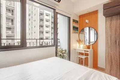 a bedroom with a bed and a large window at ClaySky Staycation S2T1-Cozy & Homey 1BR Apartment near MOA facing Pool with Own Parking with Netflix, HBO Max YouTube Premium & up to 200mbps Wifi in Manila