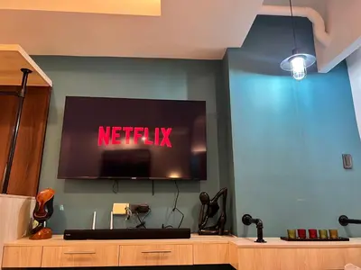 a tv on a wall with a netflix sign on it at Comfty, Chic & Spacious Room with Parking & WiFi in Manila