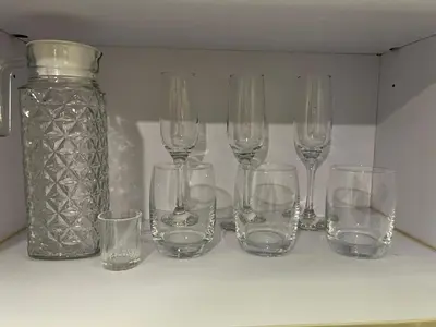 a group of wine glasses and a jar on a shelf at Comfty, Chic & Spacious Room with Parking & WiFi in Manila
