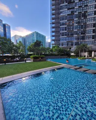 a swimming pool in a city with tall buildings at Staycations Up Above 14 @ BGC 1BR in Manila