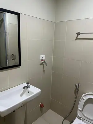 a bathroom with a sink and a toilet and a mirror at Fame Residences Mandaluyong 1 Bedroom City View in Manila