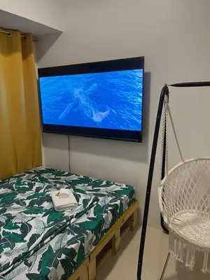 a room with a tv on the wall with a swing at Fame Residences Mandaluyong 1 Bedroom City View in Manila