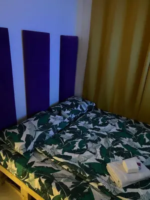 a bed with a green and white comforter at Fame Residences Mandaluyong 1 Bedroom City View in Manila
