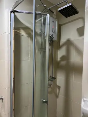 a shower with a glass door in a bathroom at Fame Residences Mandaluyong 1 Bedroom City View in Manila