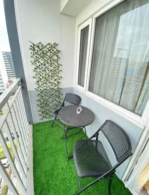 a balcony with two chairs and a table and a window at Shell Residences by Amonbrey Suite nr airport in Manila