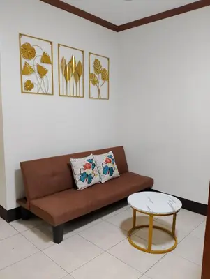 a brown couch and a table in a room at Makati Transient Condo 3BR with Balcony, Wifi in Manila
