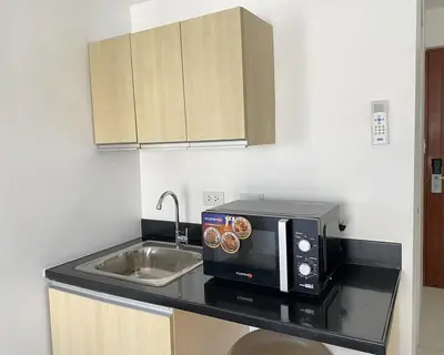a kitchen counter with a microwave and a sink at Dian SUITES 1 in Manila