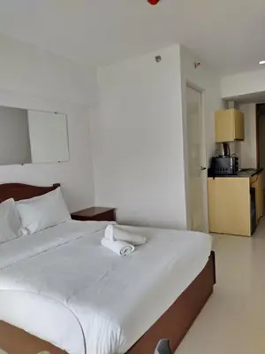 a bedroom with a bed with a towel on it at Dian SUITES 1 in Manila