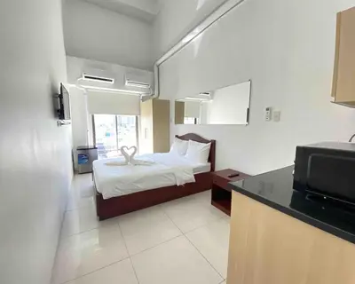 a hotel room with a bed and a television at Dian SUITES 1 in Manila