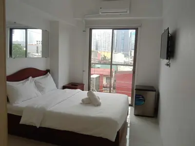 a bedroom with a bed with a stuffed animal on it at Dian SUITES 1 in Manila