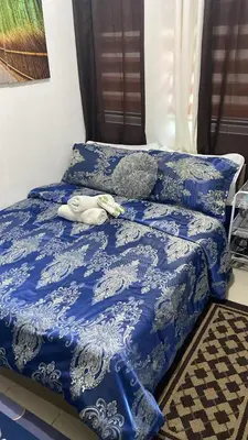 a bed with a blue comforter with a stuffed animal on it at pierrecondotel in Manila