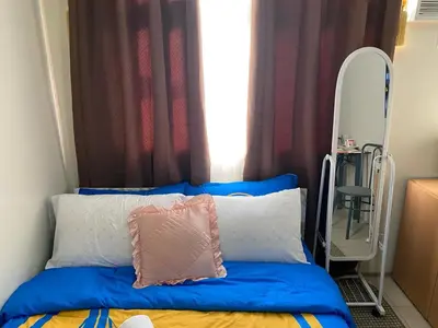 a bed with a pillow and a mirror in a room at pierrecondotel in Manila