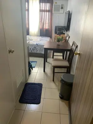 a room with a table and a table and a chair at pierrecondotel in Manila