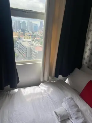 a bed in a room with a window at pierrecondotel in Manila